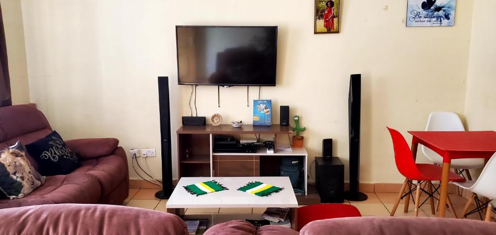 a living room with a couch and a flat screen tv at 2 Bedroom Apartment in Langata in Nairobi