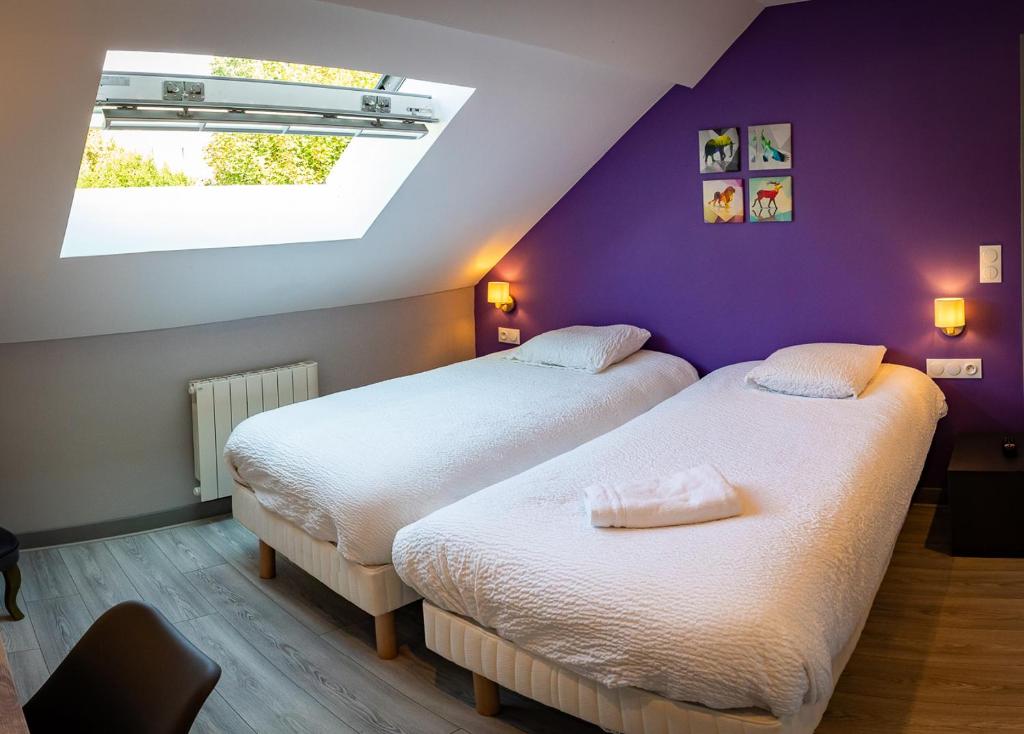 ヴィルヌーヴ・ル・ロワにあるRésidence Hermès Paris Orly Aéroportの紫色の壁の部屋にベッドが2つある