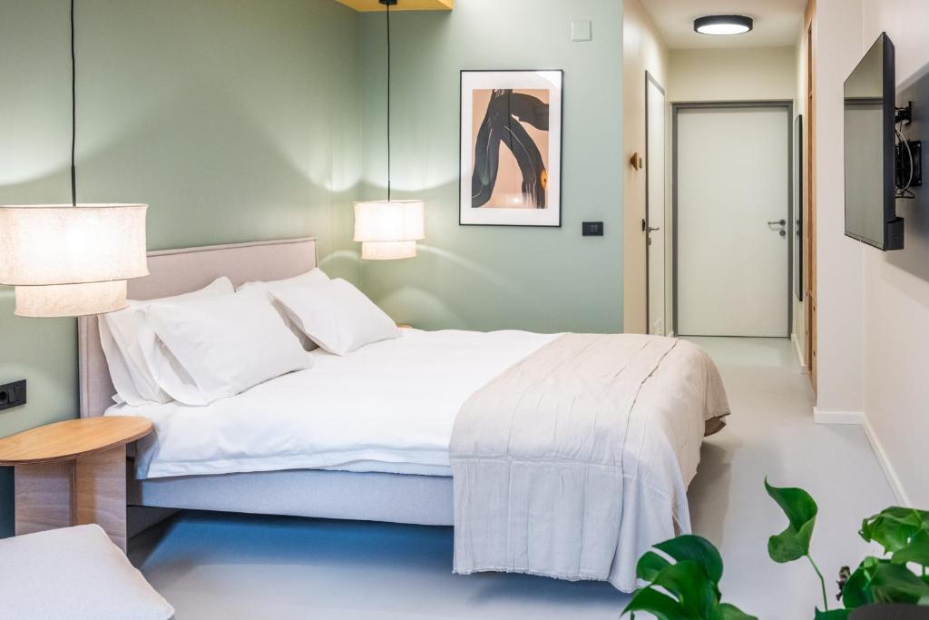 a bedroom with a large white bed and a table at Superb Petrova Street Rooms in Zagreb