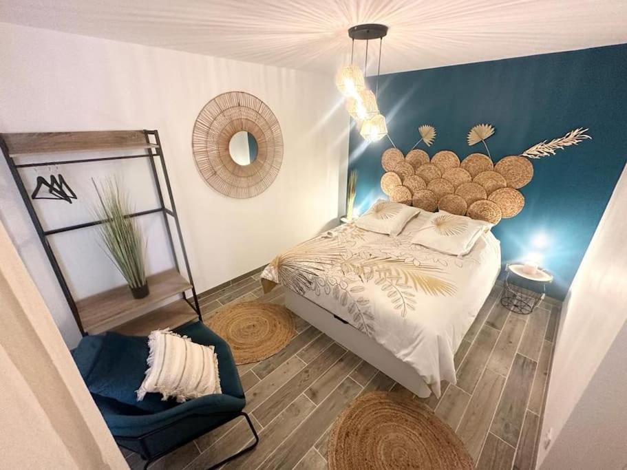 a bedroom with a bed and a chair in it at L'Evasion - Climatisé - Jardin - Plage - Jacuzzi in Perpignan