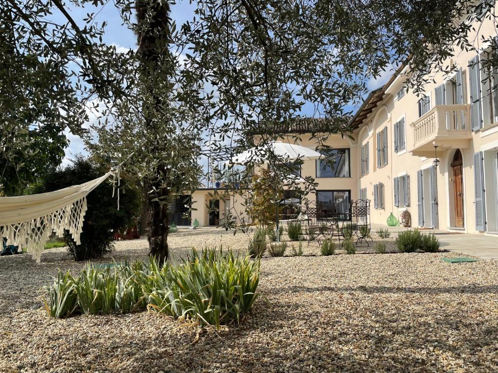 a house with a hammock in front of it at Tenuta Dei Vicini - Luxury Apartments in San Marzano Oliveto