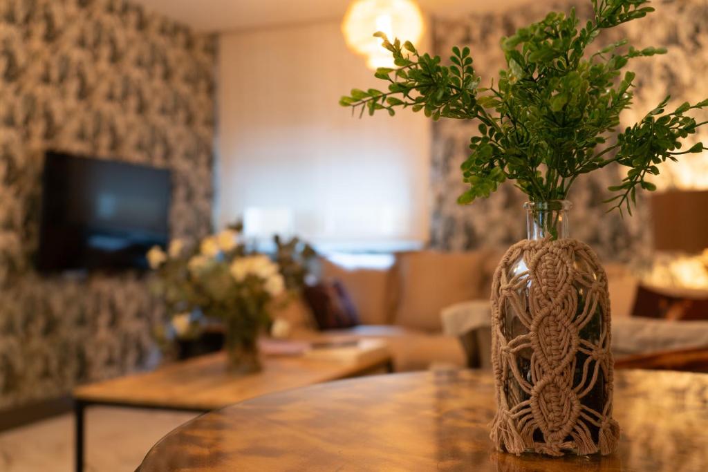 a vase with flowers on a table in a living room at Hotel Don Diego in Suances