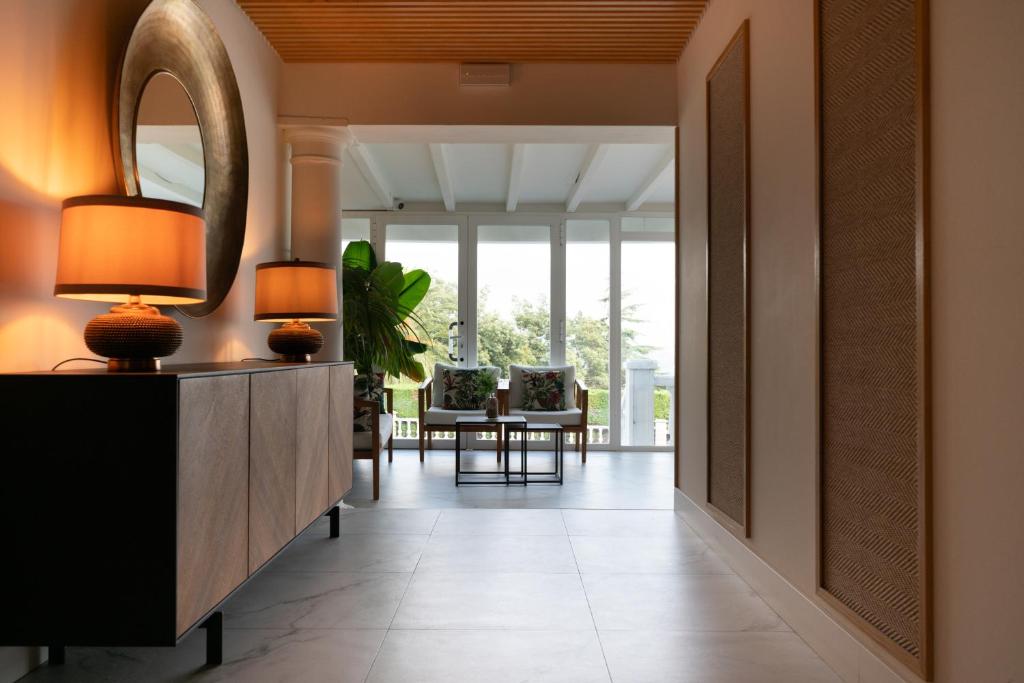 a hallway with a mirror and a table at Hotel Don Diego in Suances