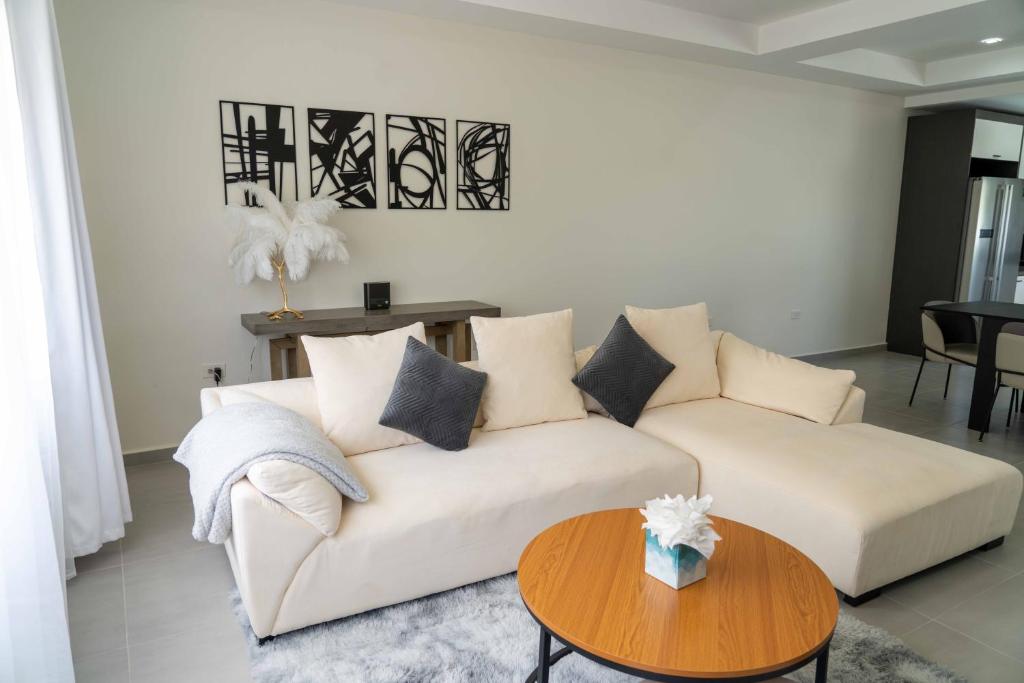 ein Wohnzimmer mit einem weißen Sofa und einem Tisch in der Unterkunft Spacious 3BR Home with Own Private Cozy Pool in Koolbaai