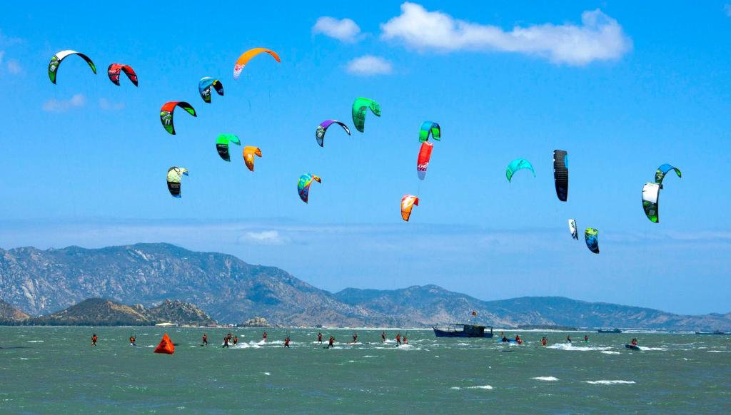 a group of people flying kites in the ocean at Ninh Chử House in Ninh Hải