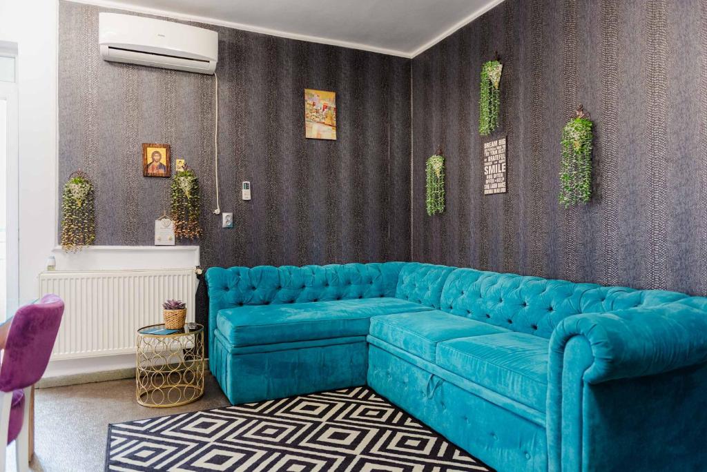 Una sala de estar con un sofá azul en una habitación. en AZUR CYAN HOUSE, en Bucarest