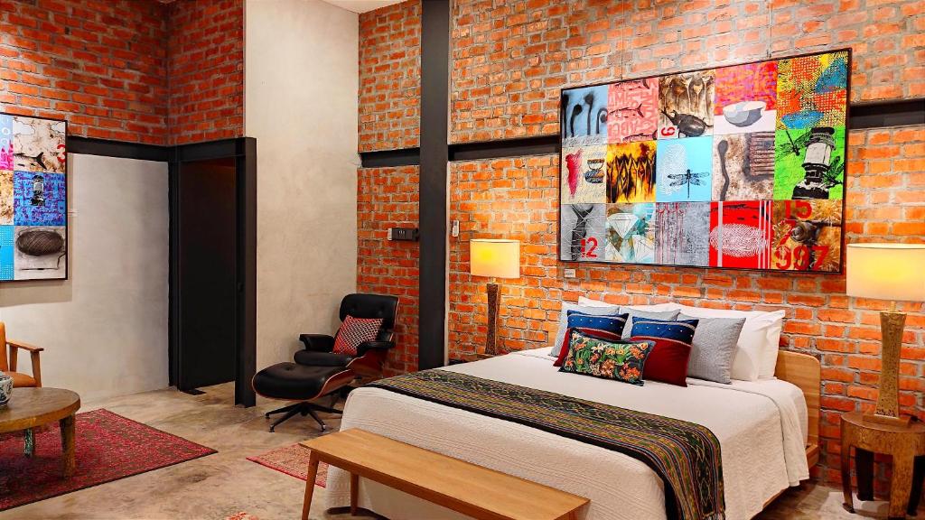 a bedroom with a bed and a brick wall at S`ekar Pinang Langkawi in Pantai Cenang