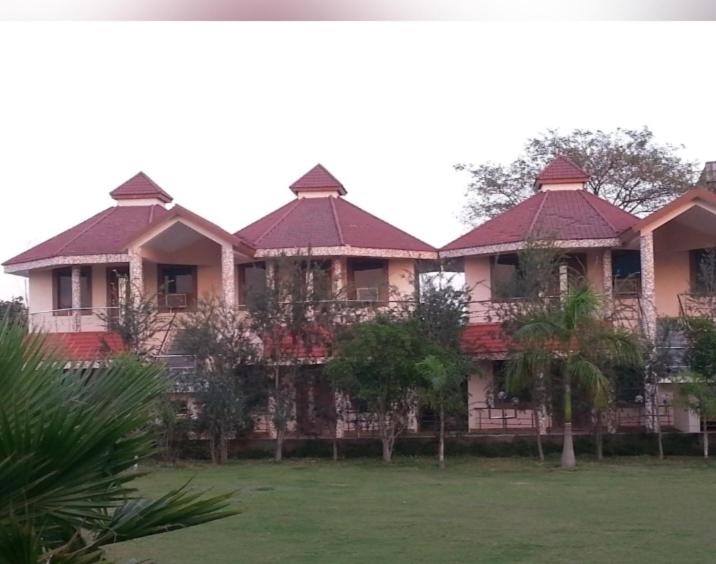 une grande maison avec des toits rouges et une cour dans l'établissement Relax INN Hotel & Resort, à Korba
