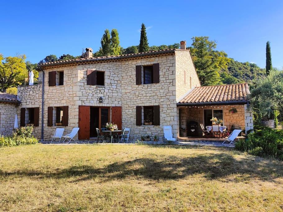 Casa de piedra grande con mesa y sillas en Maison spacieuse idéale pour vacances en famille, en Montbrun-les-Bains