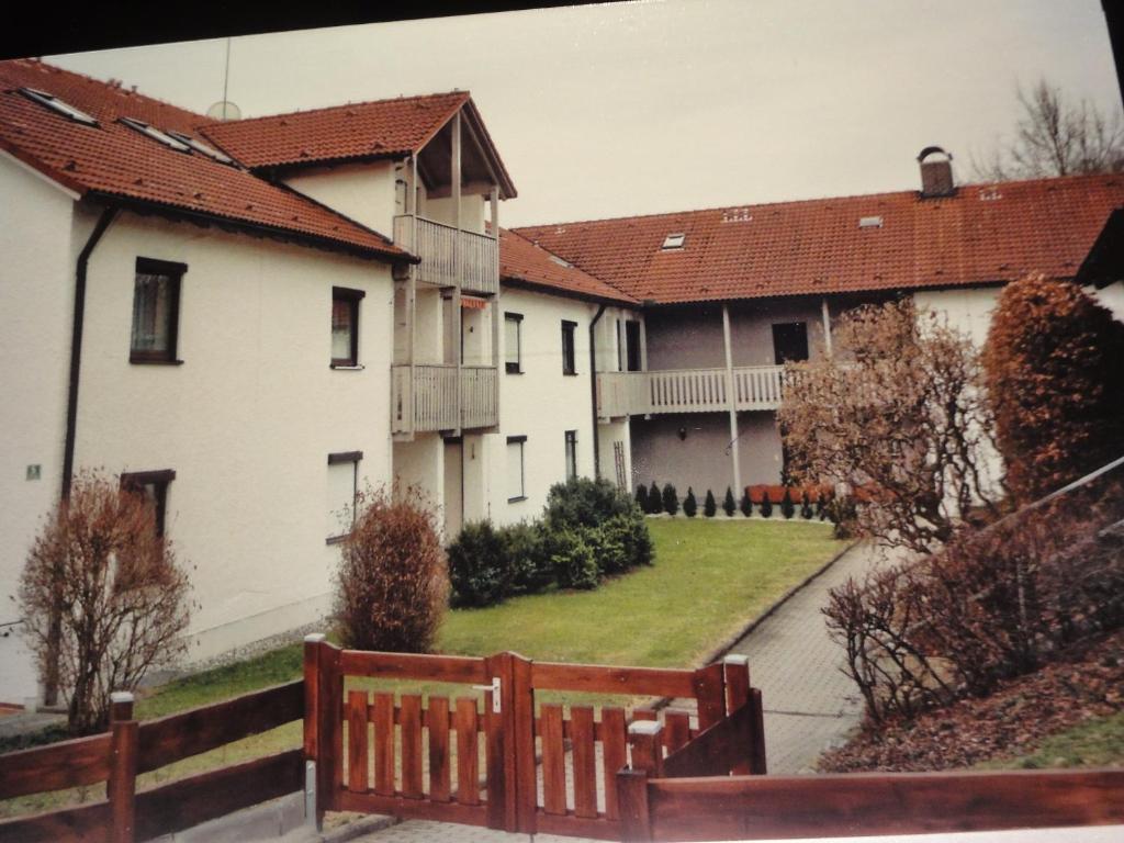 eine Gruppe weißer Häuser mit einem Holzzaun in der Unterkunft Ferienwohnung Majo in Bad Birnbach