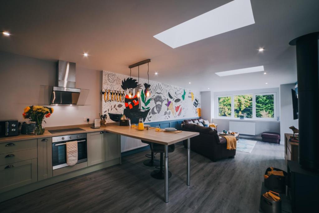 a kitchen with a table in the middle of a room at The Cosy Coo Shed in Forfar