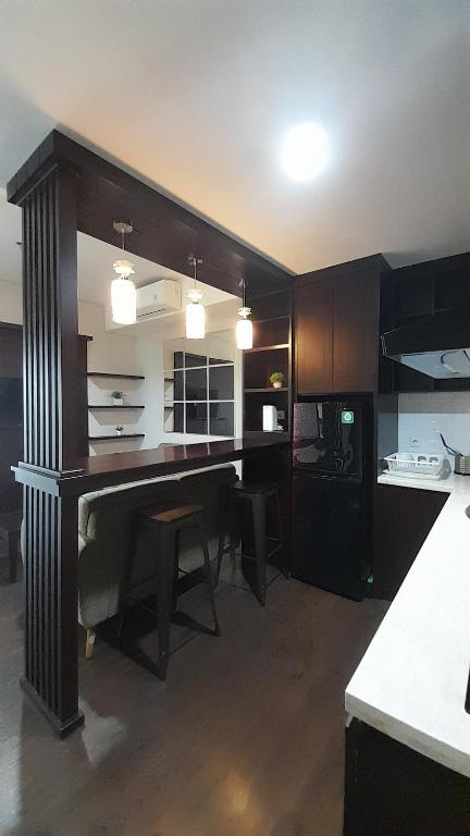 uma cozinha com uma grande secretária de madeira num quarto em Ruby Apartment #22 em Kejayan