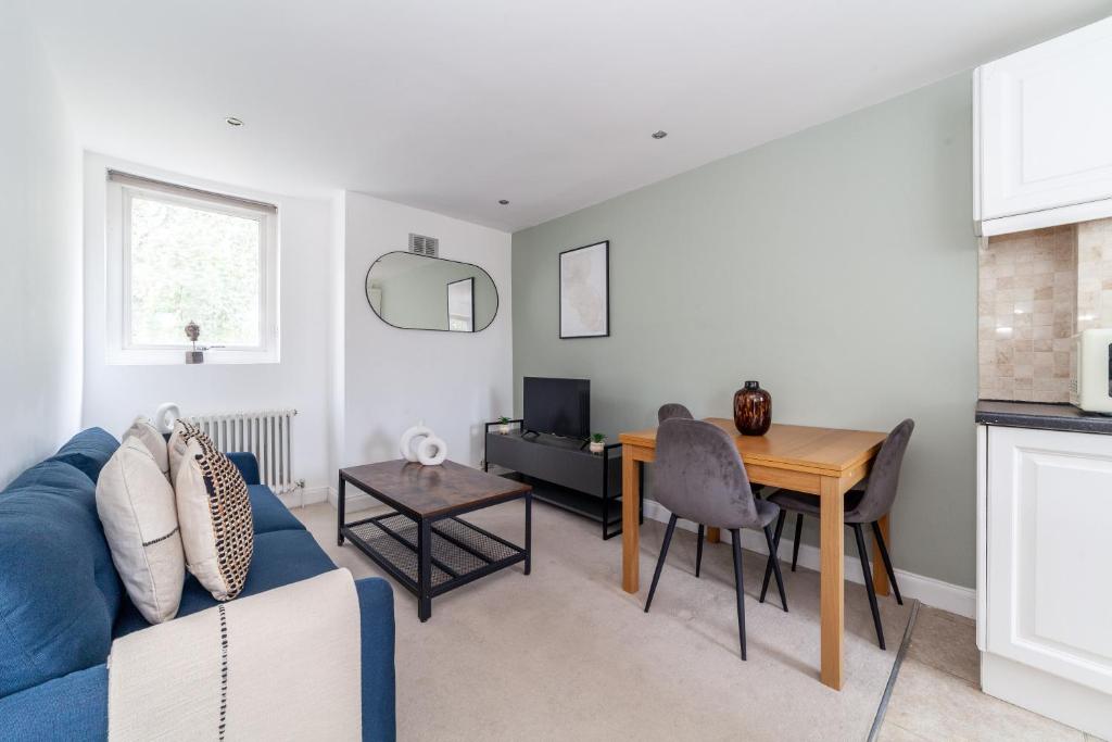 a living room with a blue couch and a table at The Wandsworth Flat in Bromley