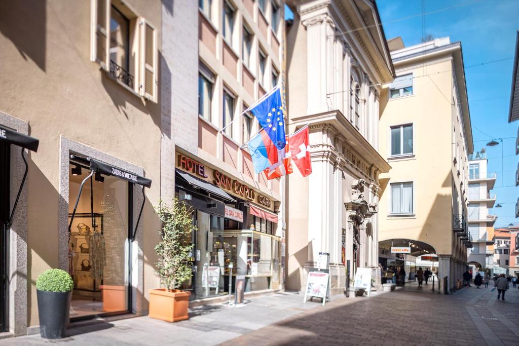 ein Gebäude mit Flaggen auf der Straßenseite in der Unterkunft San Carlo Apartments in Lugano
