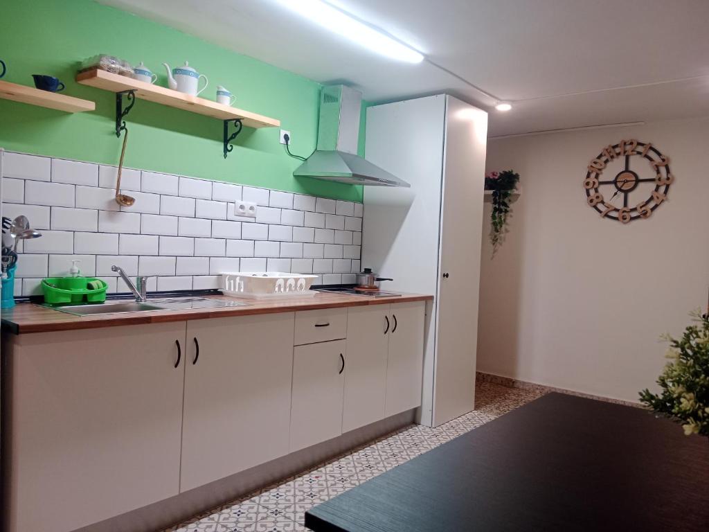 a kitchen with white cabinets and green walls at Private Room Service - Grupo RH Santander in Santander