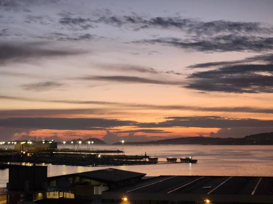 einen Sonnenuntergang über dem Wasser mit einem Pier mit Lichtern in der Unterkunft Cies Sweet Home in Vigo