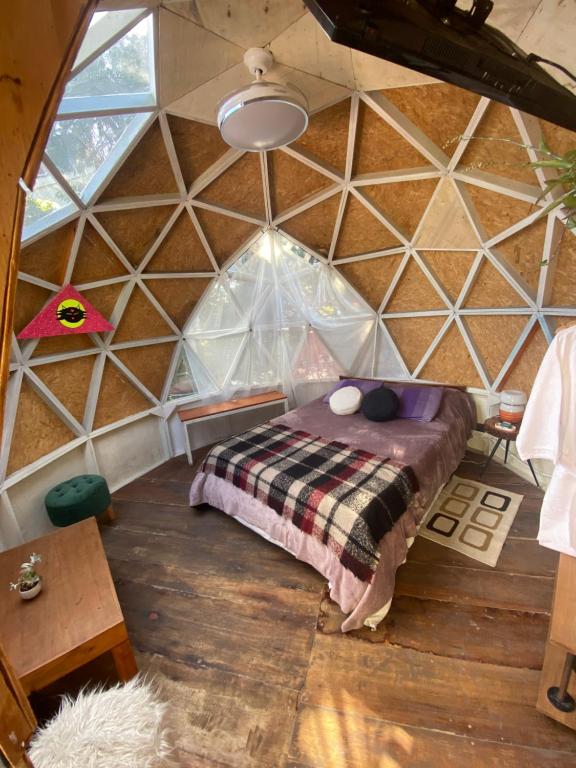 Dormitorio en forma de cúpula con cama en ProyectoQva Glamping en Villa Ballester