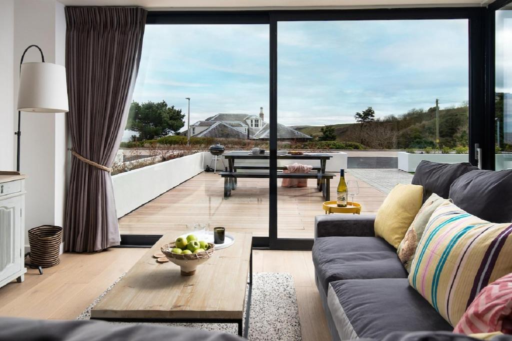 a living room with a couch and a table at 1 The Bay - Stunning contemporary flat on the Scottish coast in Coldingham