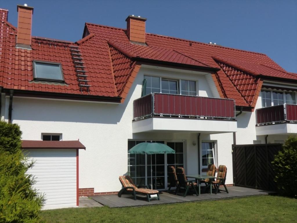 een wit huis met een rood dak bij Ferienwohnung Sünnenkringel 57 in Zingst