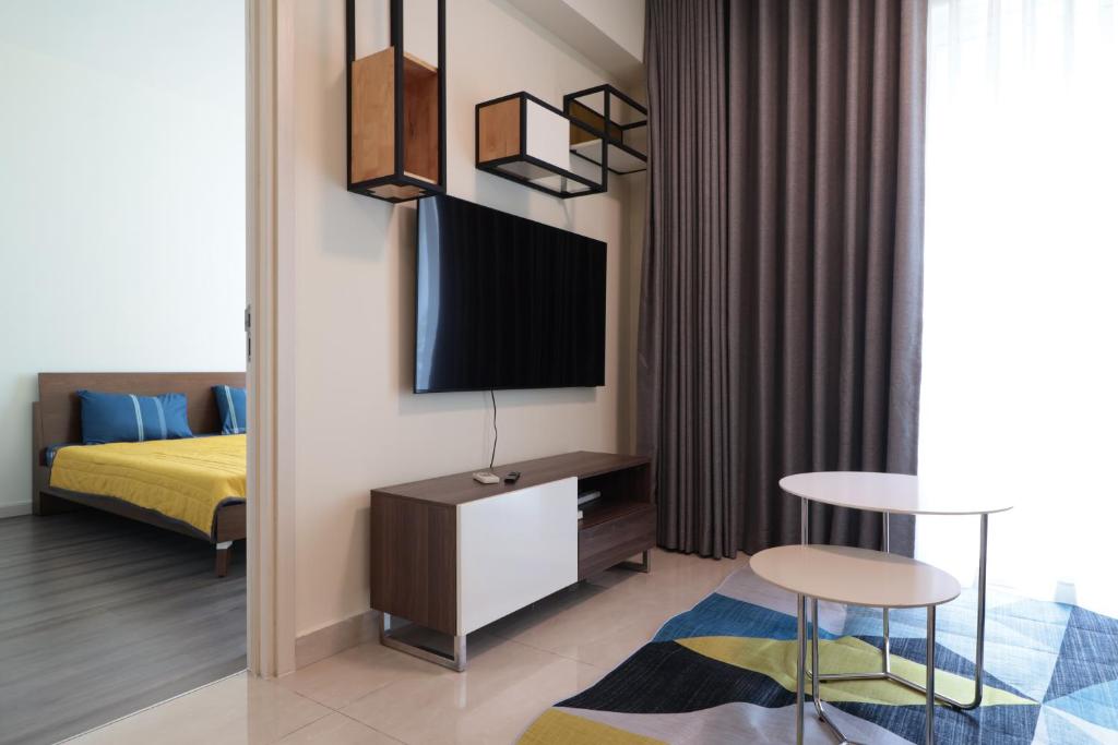 a bedroom with a bed and a tv and a table at Deluxe apartment with balcony, pool, fitness and yoga in Ho Chi Minh City