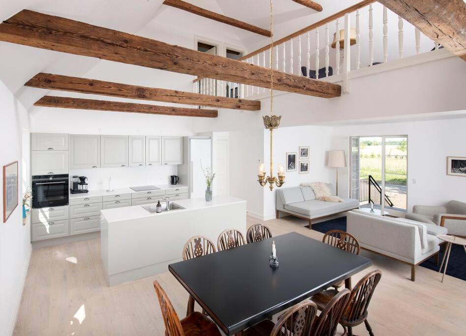 a kitchen and living room with a table and chairs at Anemonehuset på Christianssæde in Maribo