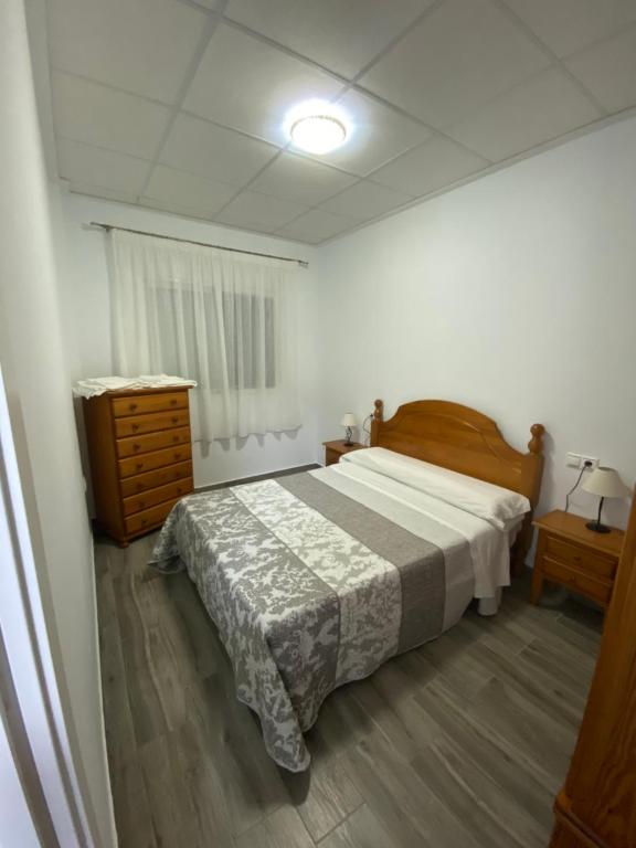 ein Schlafzimmer mit einem Bett und einer Kommode darin in der Unterkunft Apartamento Gabarron in Mula