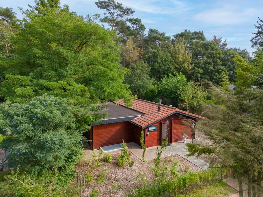 a small wooden cabin in the middle of a forest at Spacious wooden cottage with infra-red sauna at Veluwe in Putten
