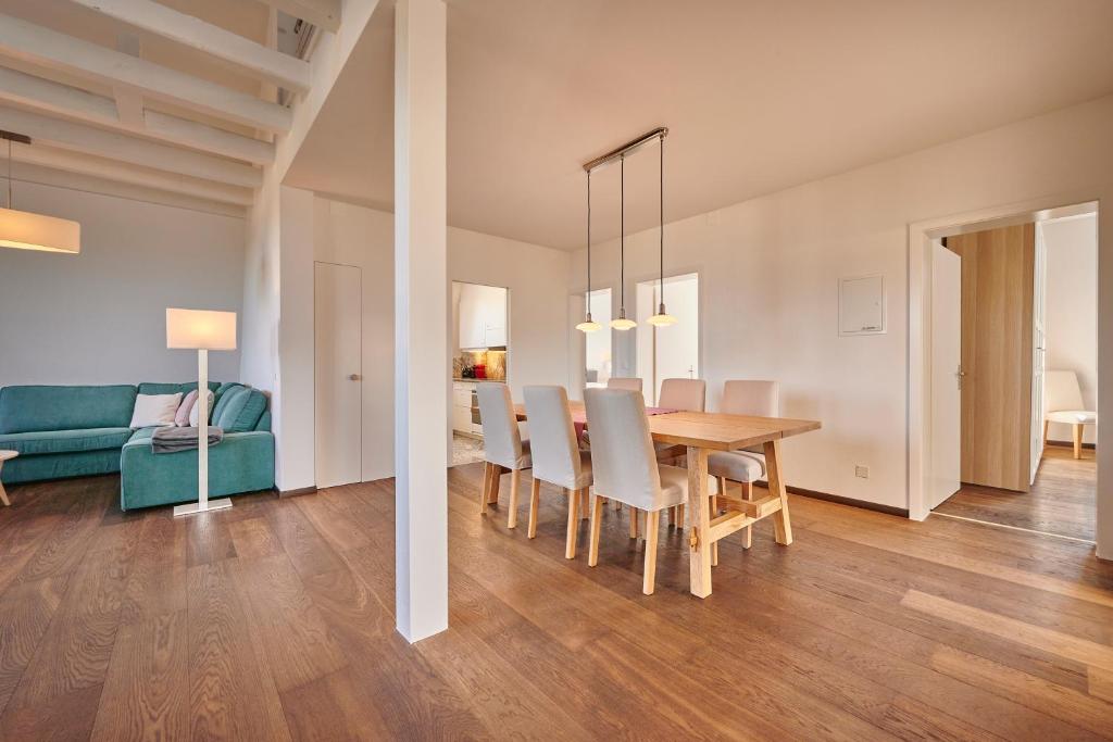 City Apartment Bern, perfect located and spacious في برن: غرفة طعام وغرفة معيشة مع طاولة وكراسي