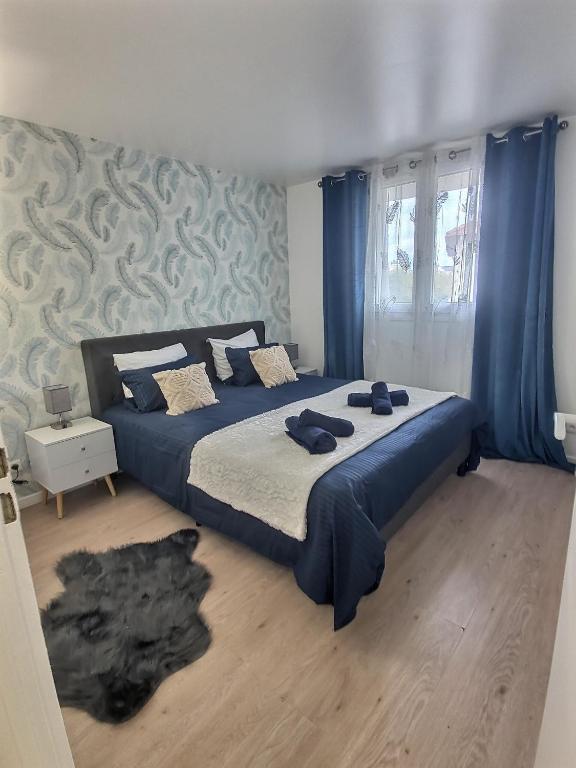 1 Schlafzimmer mit 2 Betten und blauen Vorhängen in der Unterkunft Appartement Près Gare, Parking in Vigneux-sur-Seine
