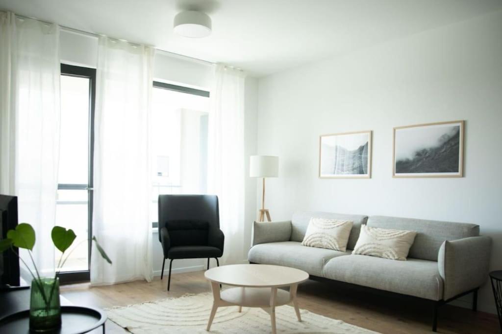 a living room with a couch and a chair at Stylish Urban Residence with parking spot in Nivy
