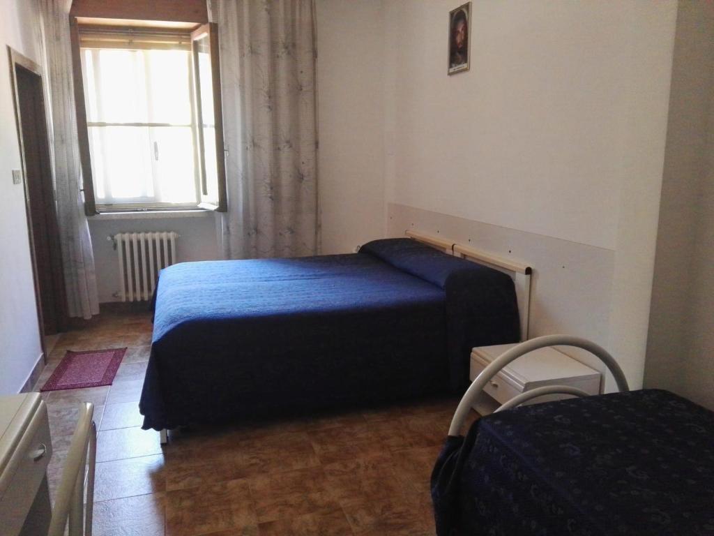 um quarto com uma cama azul e uma janela em Villa Sacro Cuore em San Giovanni Rotondo
