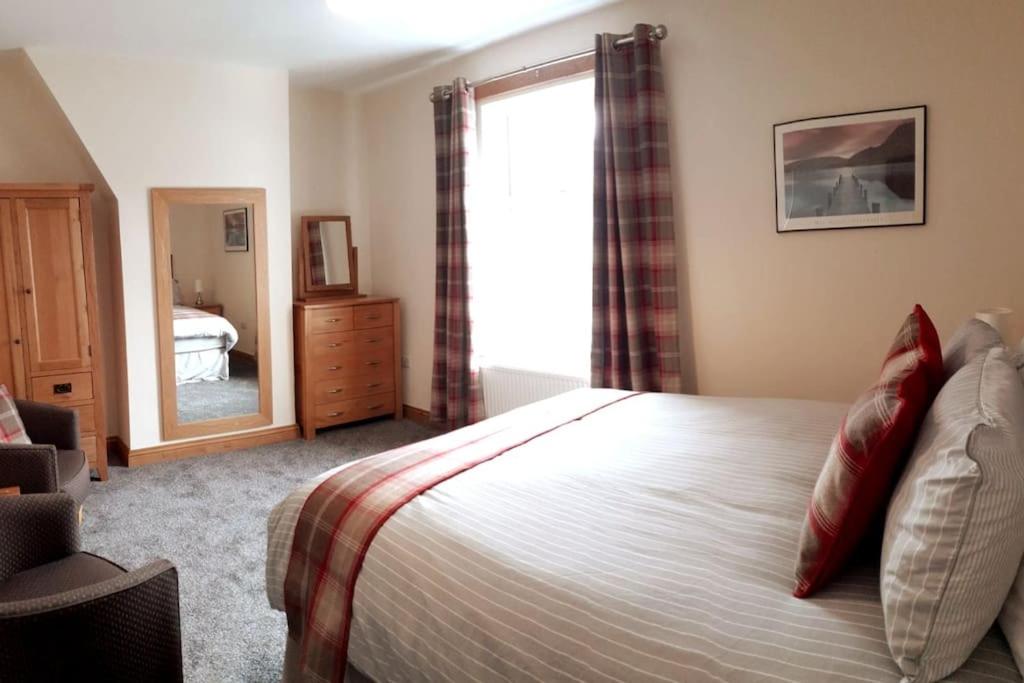 - une chambre avec un lit, une fenêtre et un miroir dans l'établissement Stunning comfortable home from home, à Millom