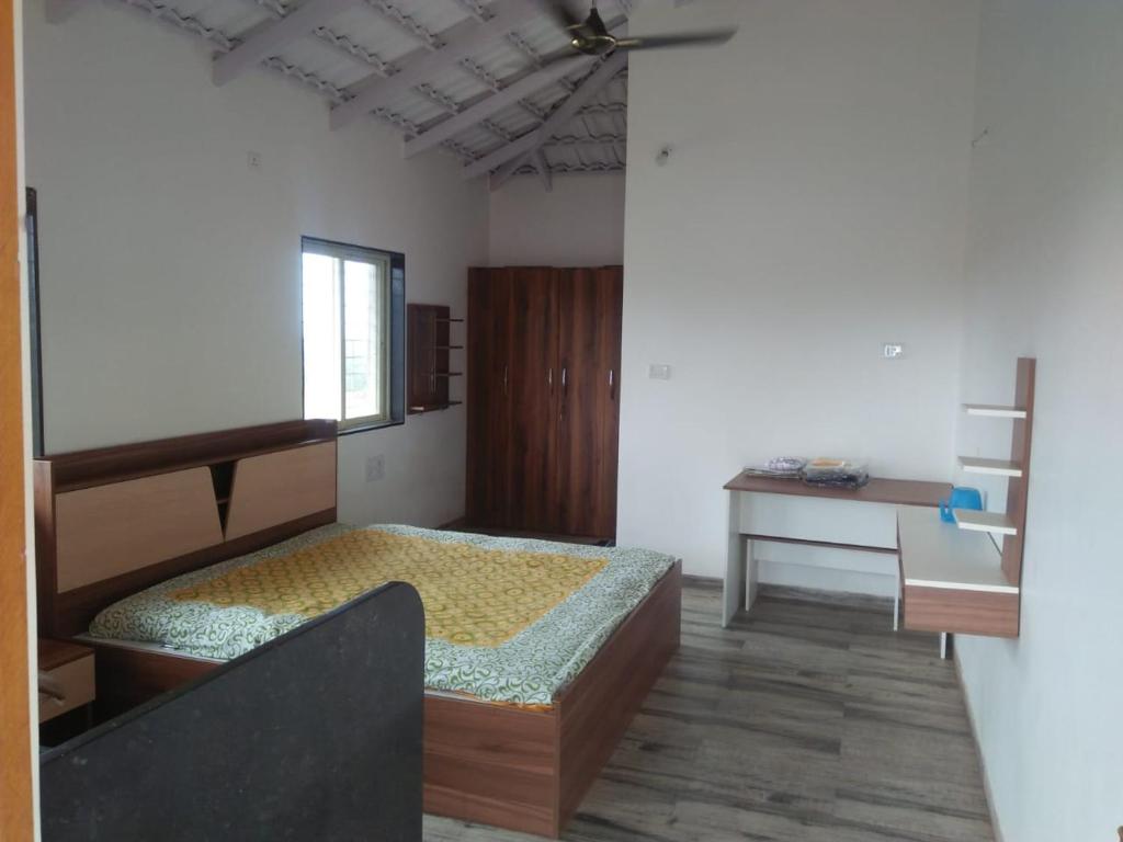 - une chambre avec un lit, un bureau et une fenêtre dans l'établissement Villa 135 Konkan Trails Dapoli Only families welcomed, à Kolthare