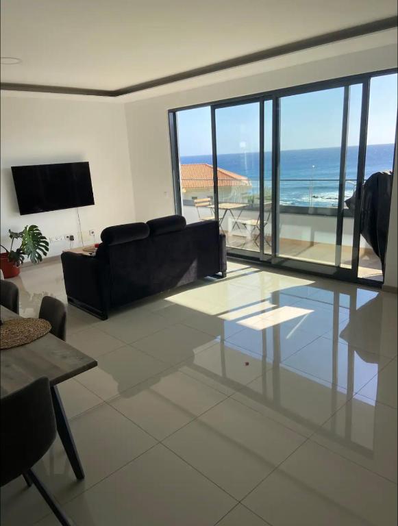 a living room with a couch and a view of the ocean at Luxury Apartment Ocean Views in Praia