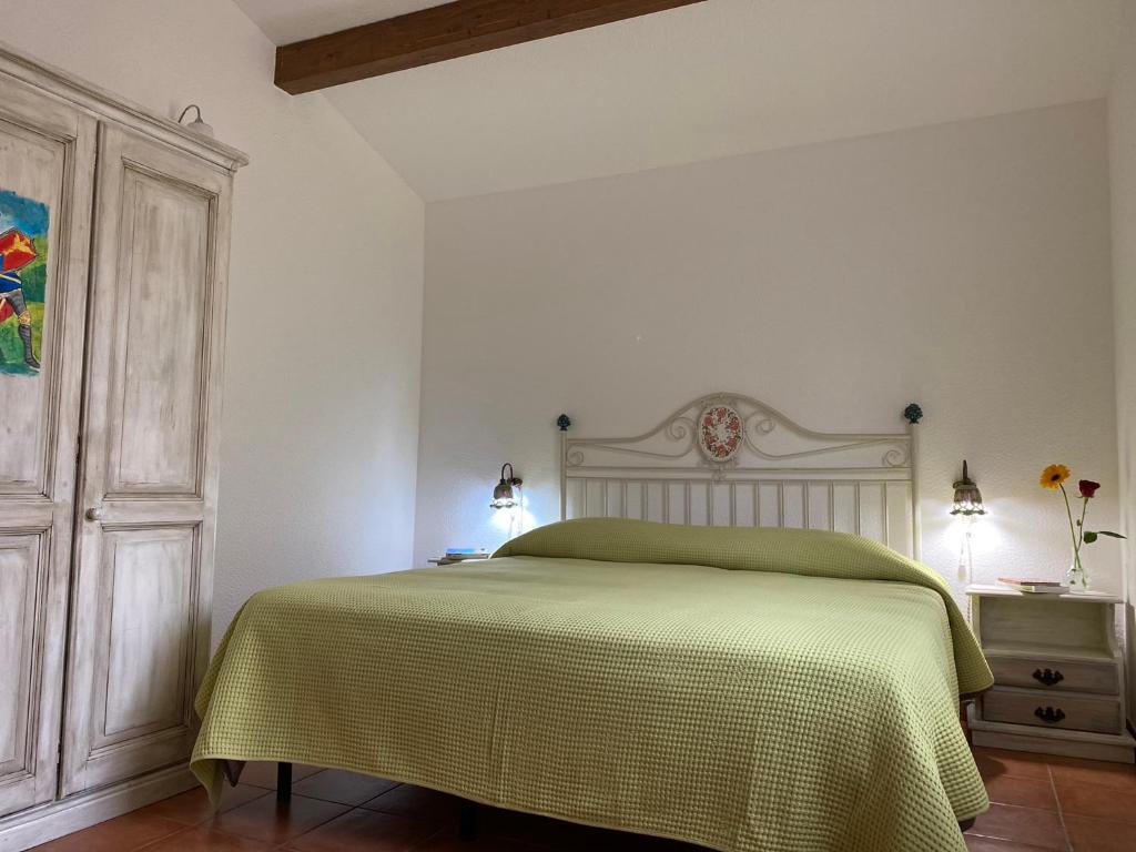 een slaapkamer met een bed met een groene deken bij Pantalica Ranch Agriturismo Siciliano in Sortino