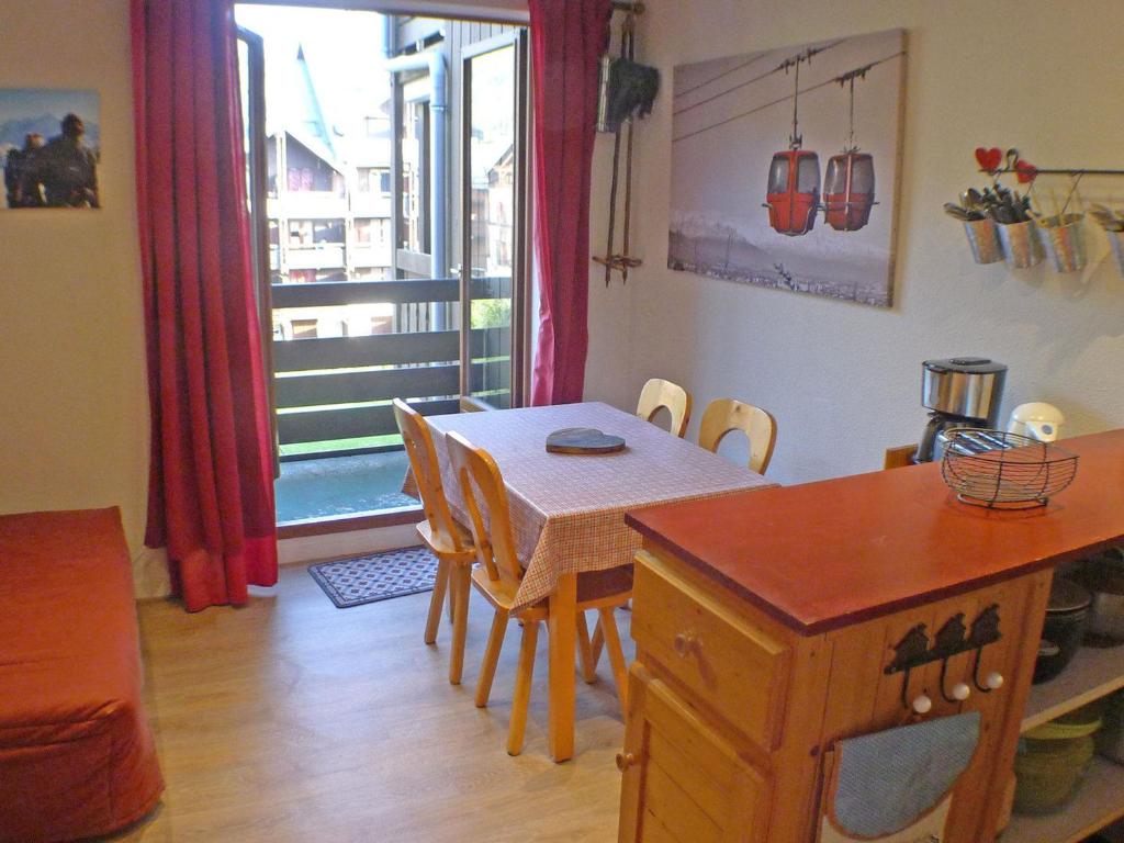 une cuisine et une salle à manger avec une table et une fenêtre dans l'établissement Appartement cosy au centre, parking et local à vélos - FR-1-629-20, à Samoëns