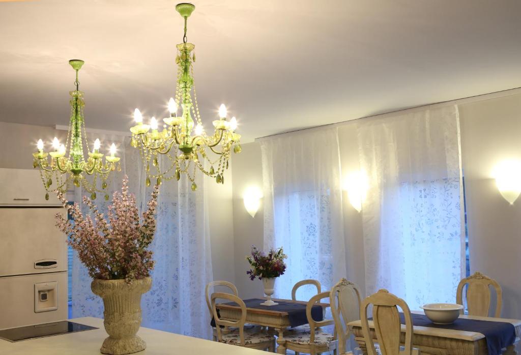 a dining room with a table and a chandelier at Pastel Guesthouse in Balatonfüred