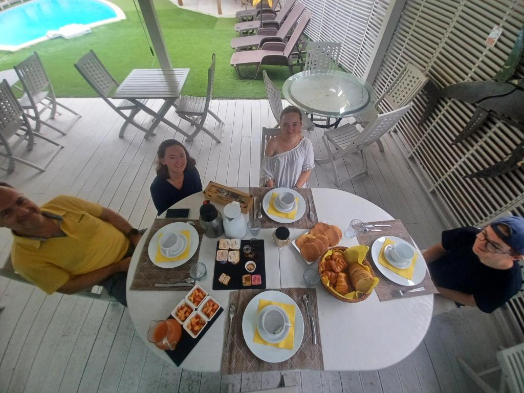a group of people sitting around a table with breakfast food at La Rose du Bresil Marie-Galante in Capesterre