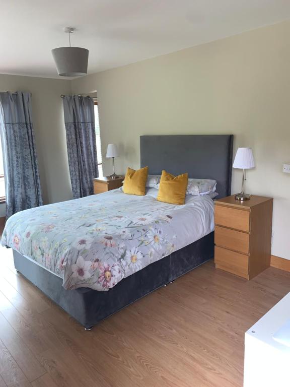 1 dormitorio con 1 cama grande con almohadas amarillas en Sliabh Amharc, en Laragh