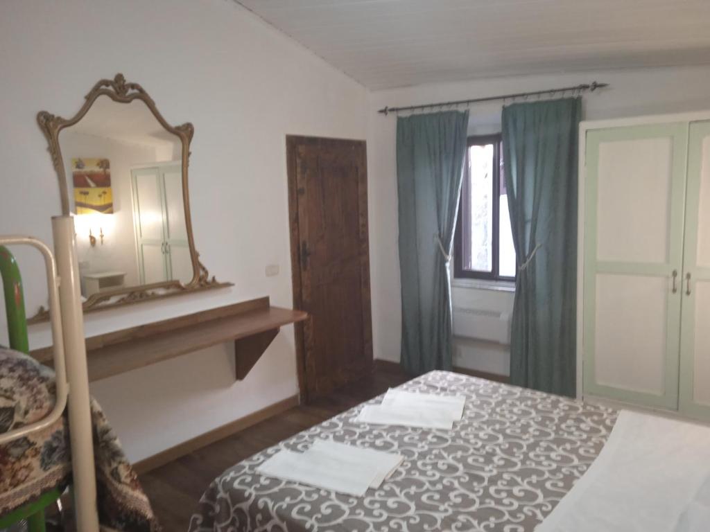 ピティリアーノにあるLa Fontanellaのベッドルーム1室(ベッド1台、鏡、窓付)