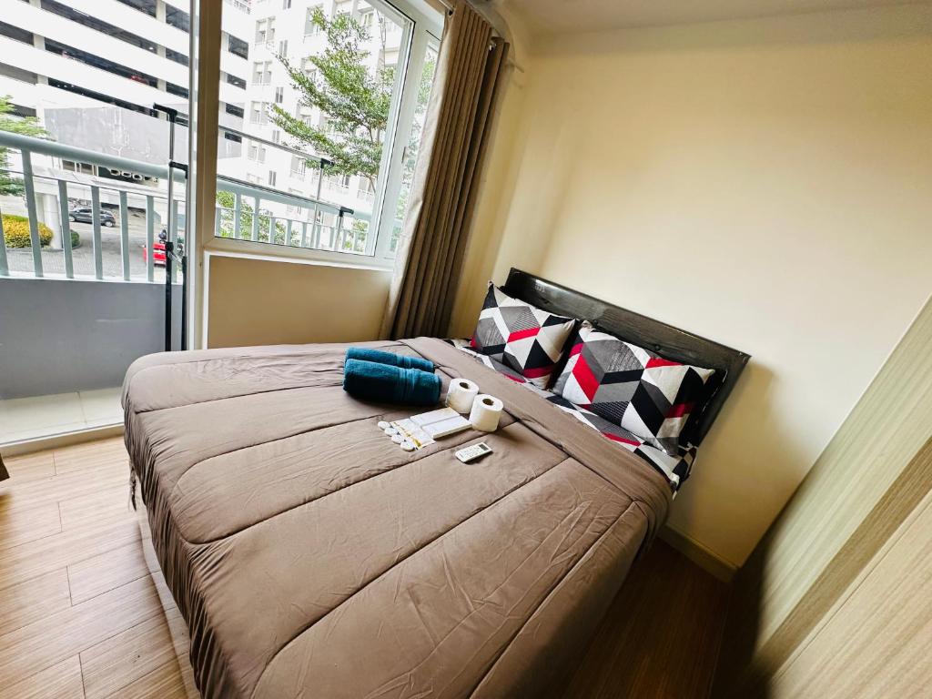 a bedroom with a large bed with a large window at Taguig 1 Bedroom with balcony Grace Residences Near Bgc in Manila