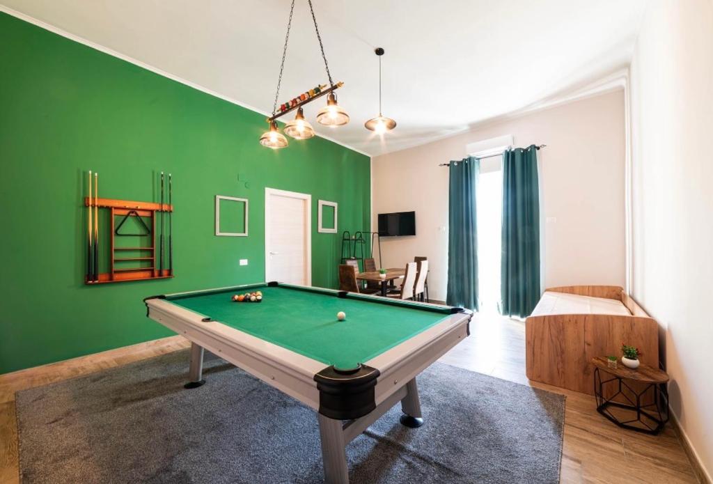 a pool table in a room with green walls at Relais Borbonico Apartment in Naples