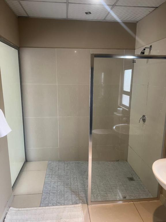 W łazience znajduje się prysznic ze szklanymi drzwiami. w obiekcie Ondangwa Rest Camp w Ondangwie