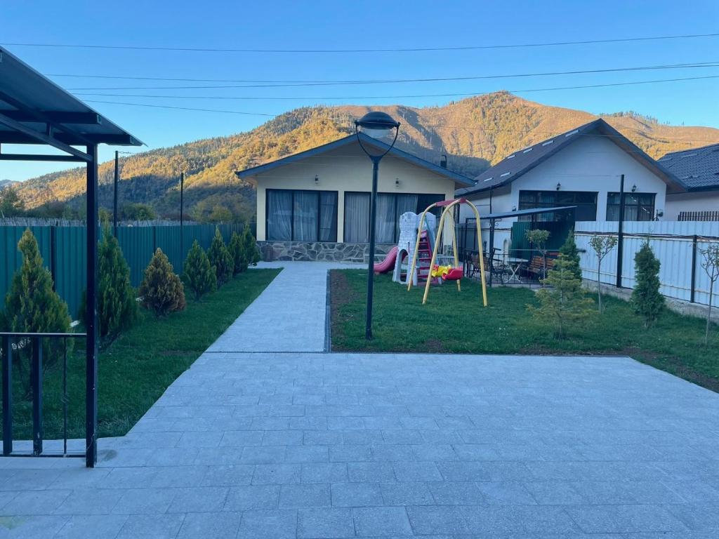 a house with a playground in the yard at Villa Borjomi in Borjomi