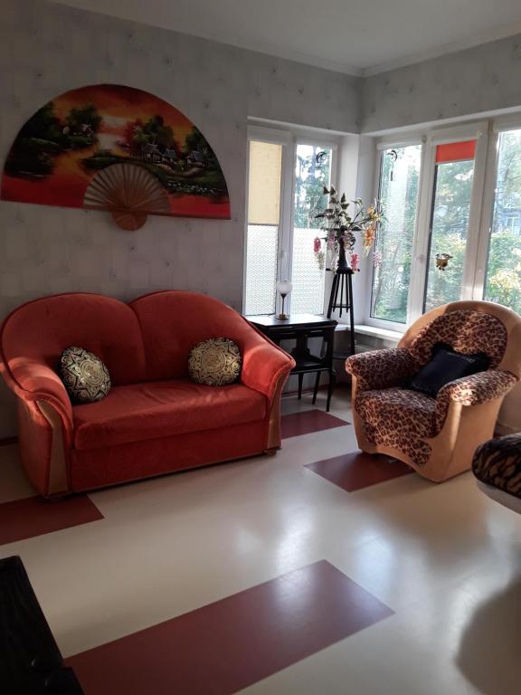 a living room with a red couch and two chairs at Jūrmala in Jūrmala