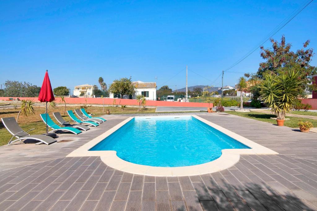 a swimming pool with lounge chairs and a pool at Mobile Home 2 - Olhão in Quelfes