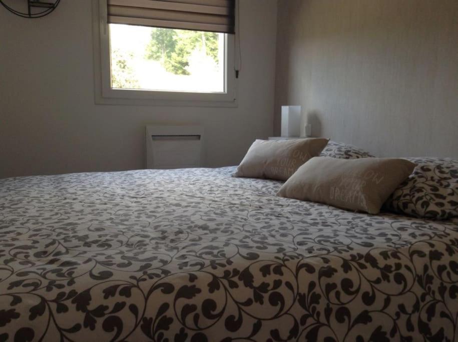 1 cama grande en un dormitorio con ventana en La Maison Bleue, en Saint-Étienne-lès-Remiremont