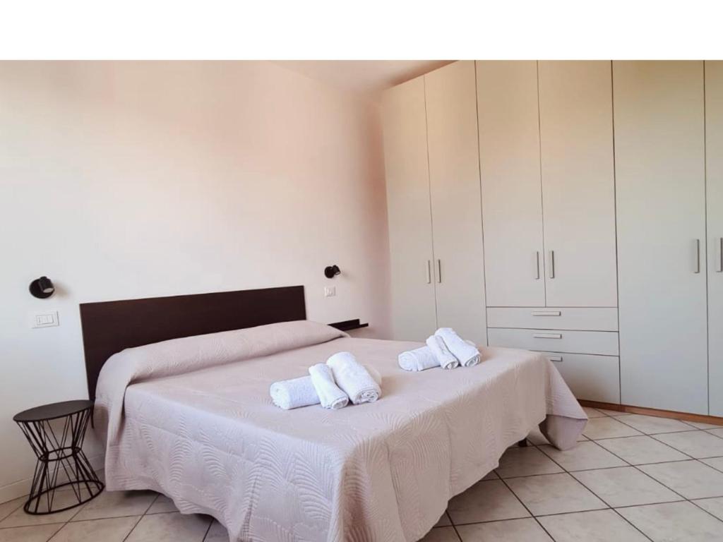 a bedroom with two beds with white sheets and towels at Olga & Giò - Vicino al Centro di Cesena in Cesena