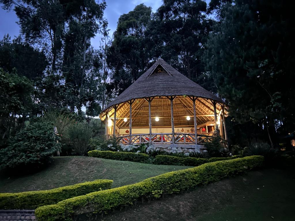 - un grand kiosque en bois dans le jardin la nuit dans l'établissement Itambira Island, Seeds of Hope, à Chabahinga