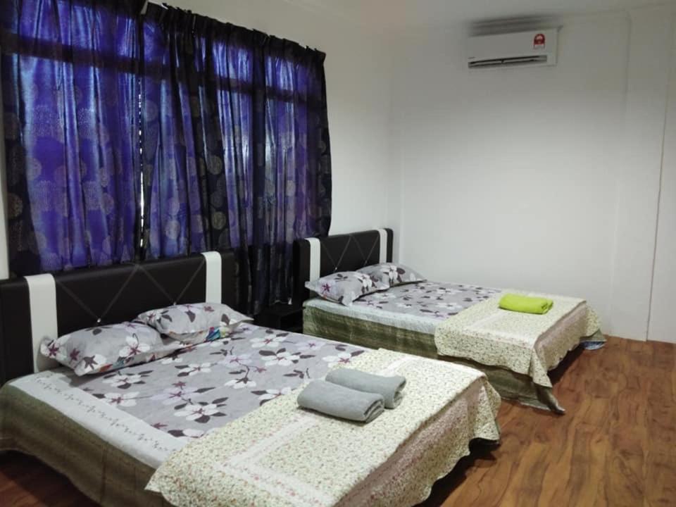 a room with two beds and a window at Alin Roomstay Dungun in Dungun